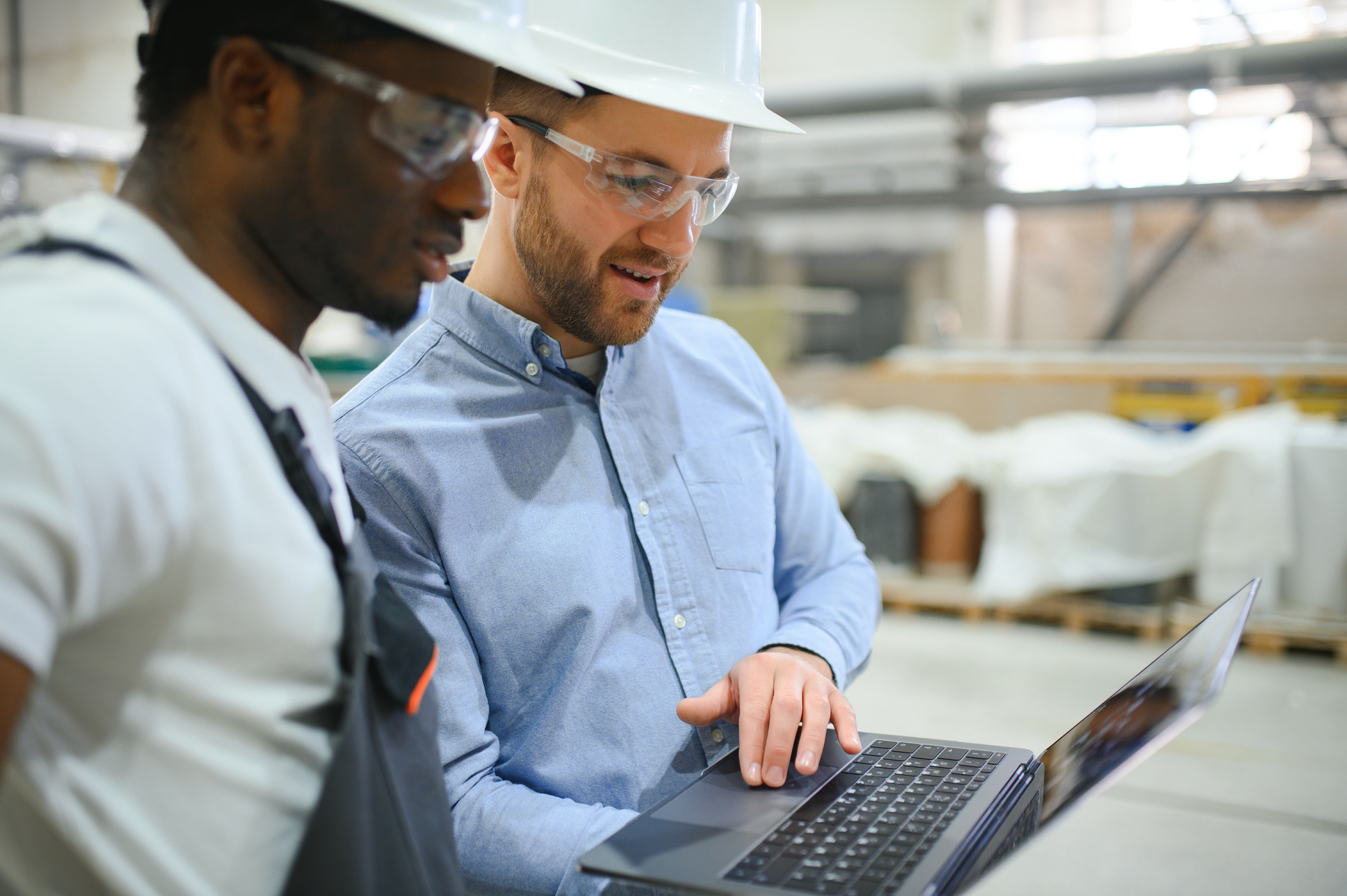 Two people reviewing work on a factory floor.
